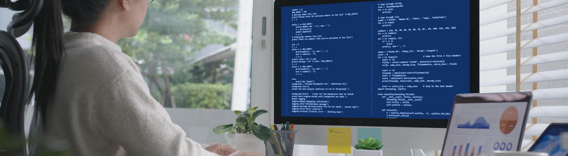 Long-haired woman sitting in front of a computer screen with codes