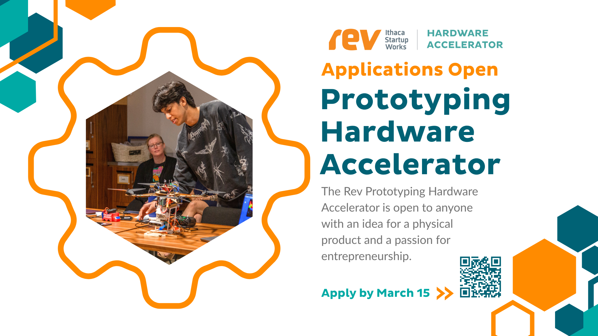 Young South Asian man wearing a black sweater and working on a prototype on a wood table 