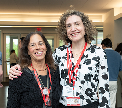 Two Caucasian women hugging and smiling in front of the camera