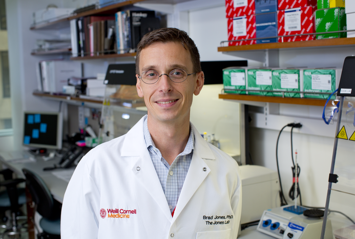 A white male doctor in white coat standing in a lab.