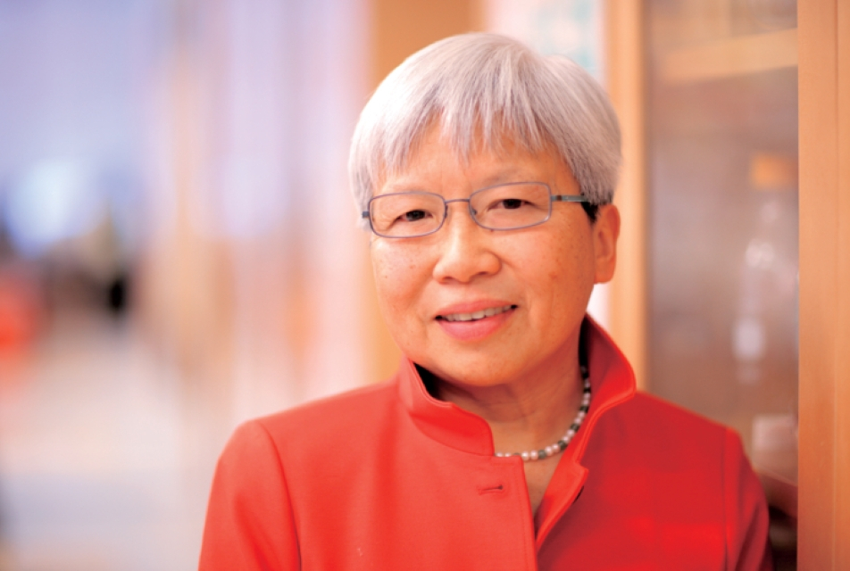 East Asian woman in white hair and wearing glasses and a red shirt