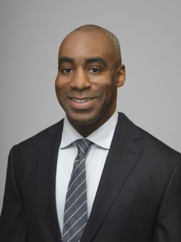 African-American man wearing a light gray tie and dark gray suit