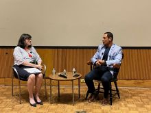 BioVenture eLab Director Loren Busby (Left) Interviewing Dr. Vishwas Seshadri A Caucasian woman and an Indian man both in business casual attire talking on stage