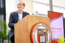 Robert Langer speaking at a podium with the Cornell University logo.