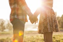 image of man and woman holding hands in the sunlight