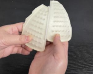Image of two hands holding the 3D printed prototype