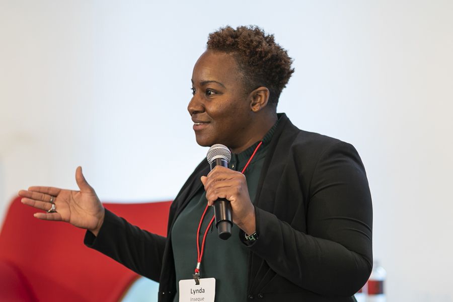 A woman in business attire talking with a microphone