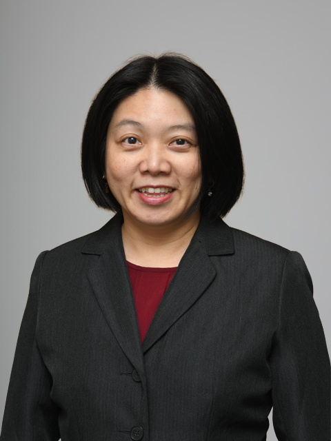 East Asian woman with a bob cut and wearing a dark gray suit
