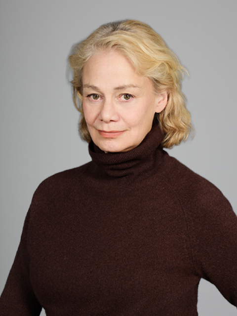Blonde Caucasian woman wearing a dark brown turtle neck