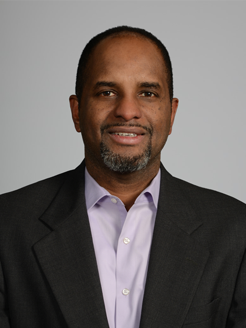 African-American man wearing a light purpose shirt and dark gray suit